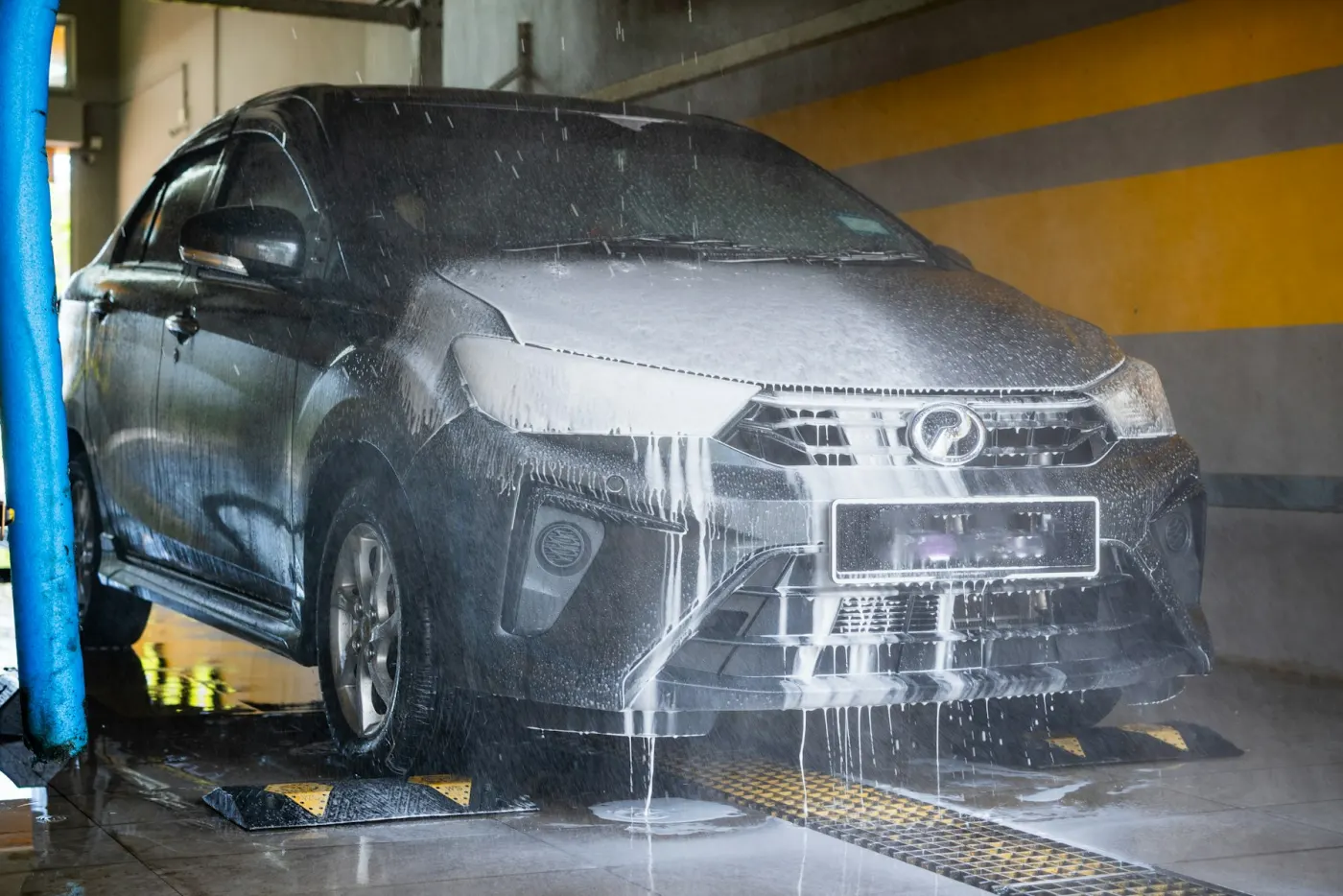 Carro cubierto de espuma en la bahía de lavado